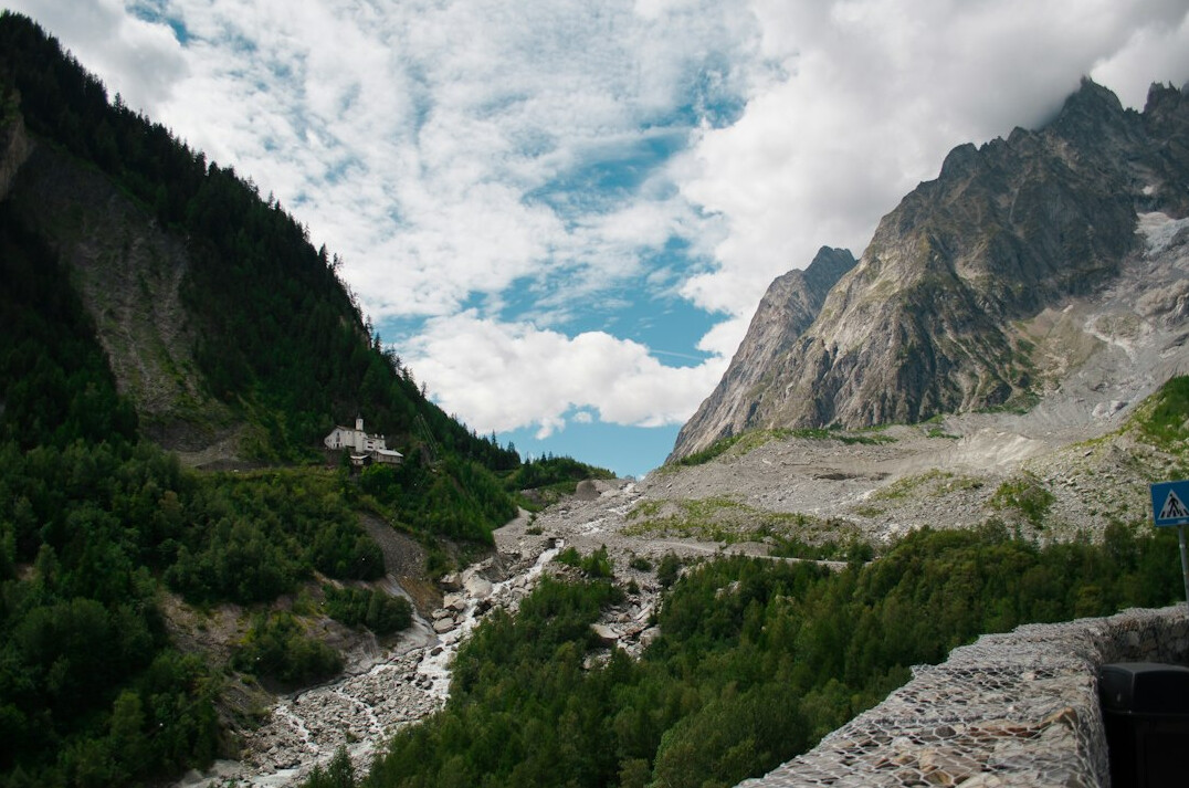 Alpine river flowing through a Swiss valley near an industrial pipe
