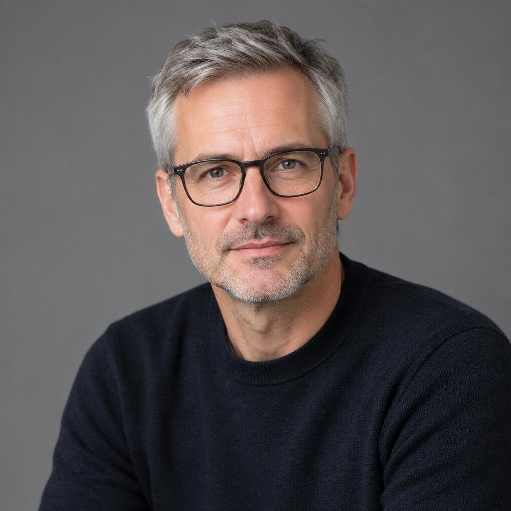 Studio portrait of a Swiss man editor with glasses